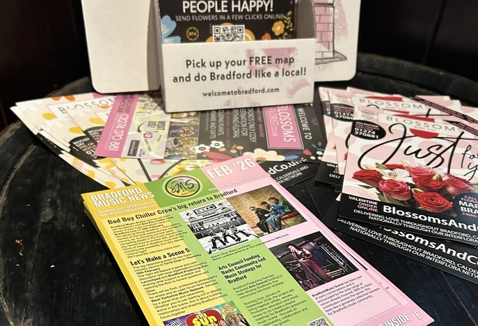 Printed gig lists on a table with other local material